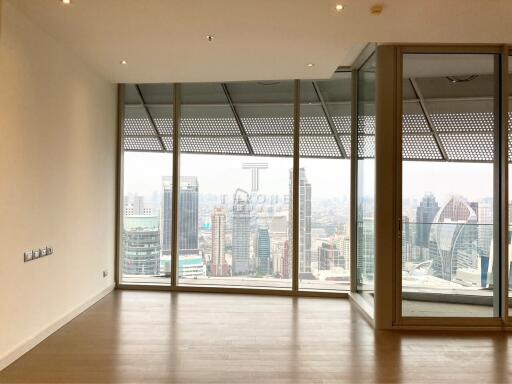 Spacious and bright unfurnished living room with large windows and city view