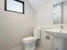 Compact modern bathroom with white tiles and natural light