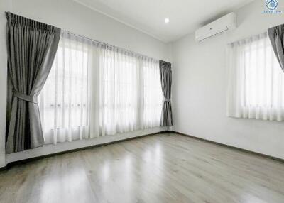 Spacious and bright empty living room with large windows and air conditioning unit