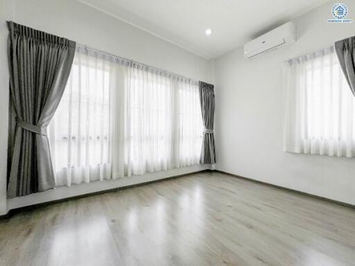 Spacious and bright empty living room with large windows and air conditioning unit