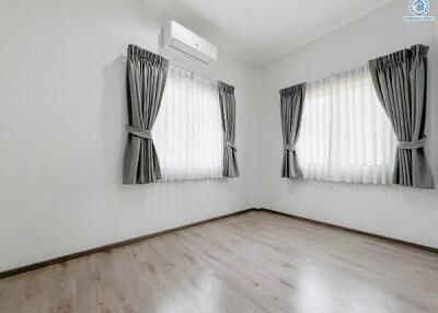 Empty bedroom with hardwood floors and air conditioning unit
