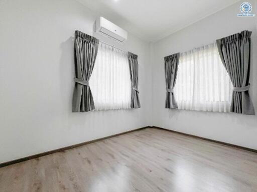 Empty bedroom with hardwood floors and air conditioning unit