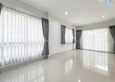 Spacious and Bright Living Room with Large Windows and Elegant Drapes