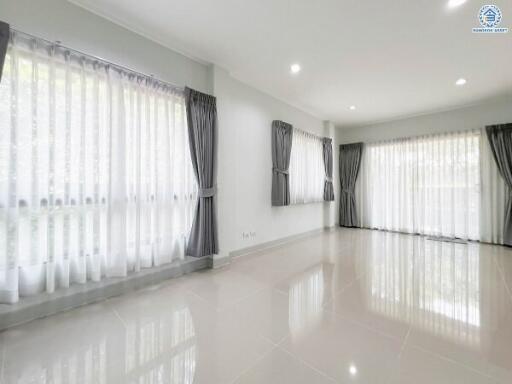 Spacious and Bright Living Room with Large Windows and Elegant Drapes