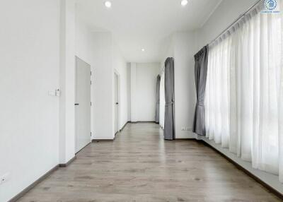 Spacious and well-lit empty room with hardwood floors and white walls