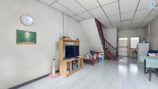 Spacious living room with staircase and ample natural light