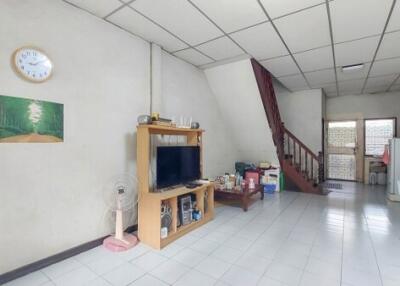 Spacious living room with staircase and ample natural light