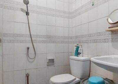 Compact bathroom with shower, toilet, and sink