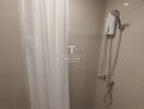 Compact bathroom with shower curtain and wall-mounted electric shower unit