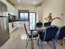 Modern kitchen with dining area, stainless steel appliances, and ample natural light