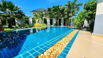 Lush backyard with a large swimming pool surrounded by tropical plants