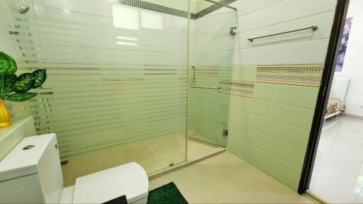 Modern bathroom with glass shower stall and green accents