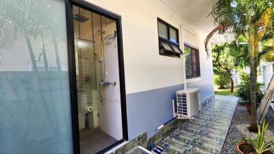 View of the outdoor area showing bathroom entrance and air conditioning unit