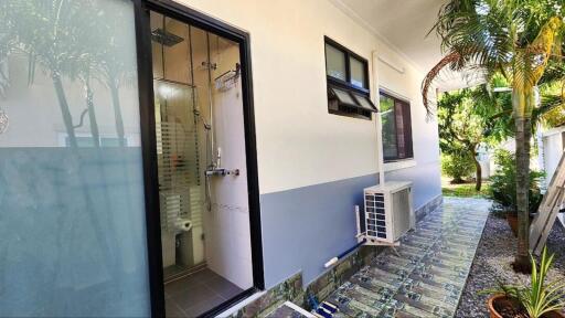 View of the outdoor area showing bathroom entrance and air conditioning unit