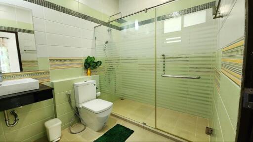 Spacious modern bathroom with walk-in shower and decorative tiling