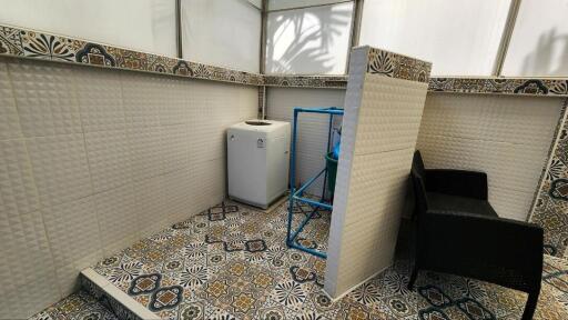 Spacious utility area with decorative tiles and washing amenities