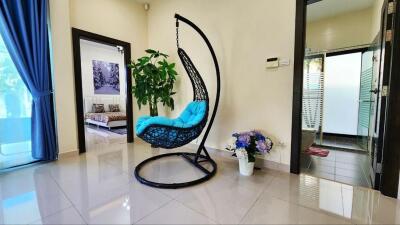 Modern living area with hanging chair and polished tile flooring