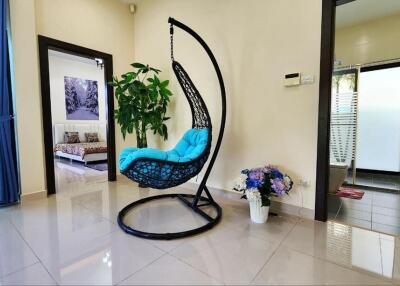 Modern living area with hanging chair and polished tile flooring