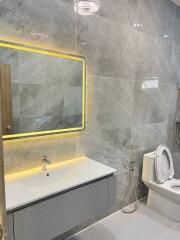 Modern bathroom with marble tiles and LED mirror lighting