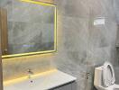 Modern bathroom with marble tiles and LED mirror lighting