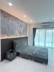 Modern bedroom with a tropical wall design and elegant furnishings