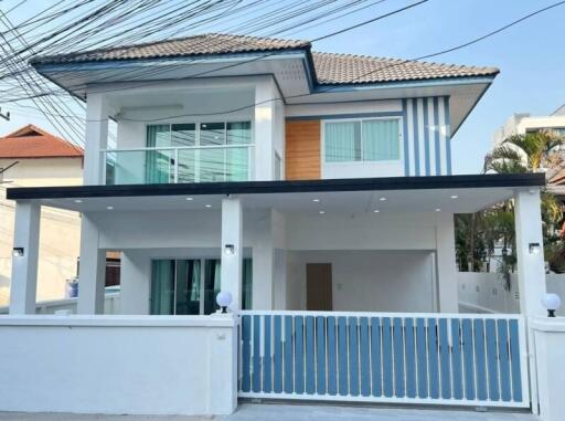 Contemporary two-story house with a white and wood facade and blue accents