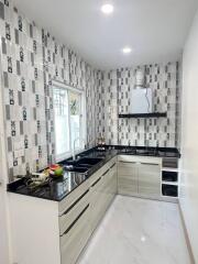 Modern kitchen with black countertops and patterned backsplash