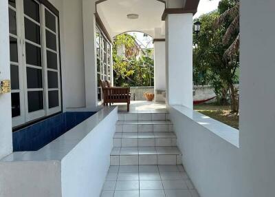 Spacious outdoor covered patio with tiled flooring and garden view