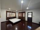 Spacious bedroom with wooden floors and natural light
