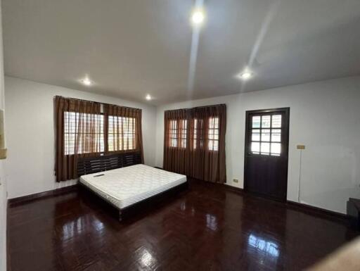 Spacious bedroom with wooden floors and natural light