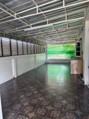 Spacious empty room with tiled floor, green window shades, and exposed metal ceiling