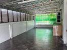 Spacious empty room with tiled floor, green window shades, and exposed metal ceiling