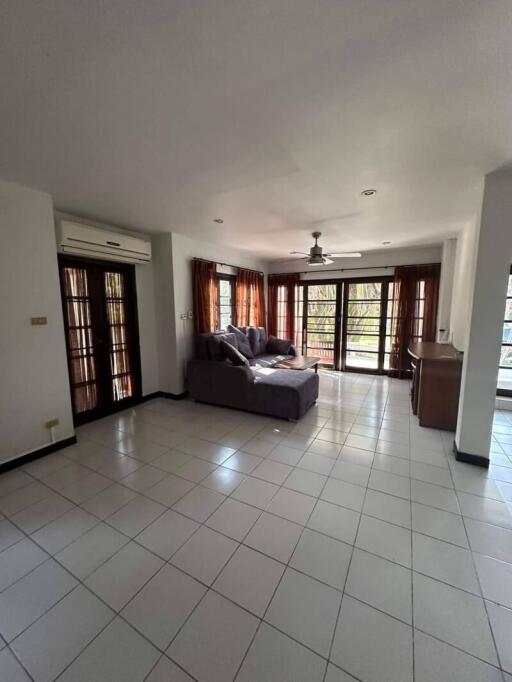 Spacious living room with tiled flooring and ample natural light