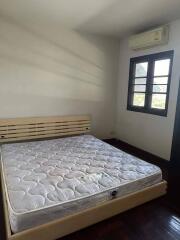 Spacious bedroom with large window and air conditioning unit