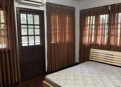 Cozy bedroom with wooden flooring and air conditioning
