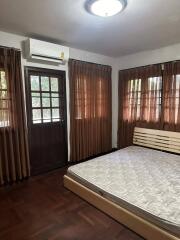 Cozy bedroom with wooden flooring and air conditioning