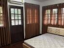 Cozy bedroom with wooden flooring and air conditioning