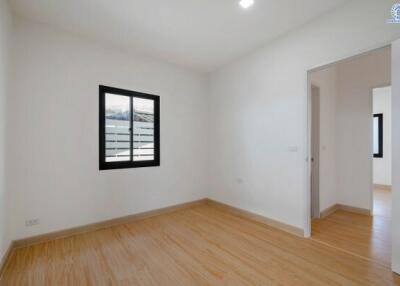 Empty bedroom with hardwood floors and white walls