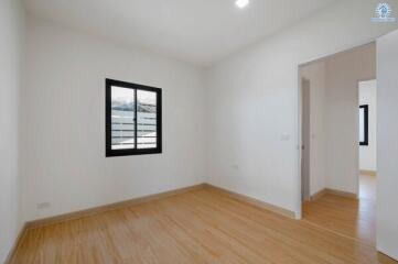 Empty bedroom with hardwood floors and white walls