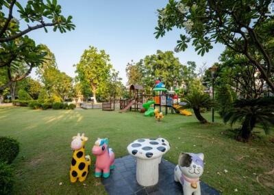 Spacious garden with a playground and seating area