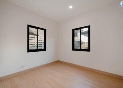 Spacious and well-lit empty bedroom with two windows