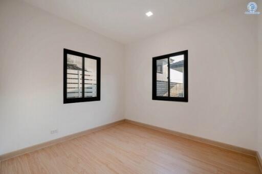 Spacious and well-lit empty bedroom with two windows
