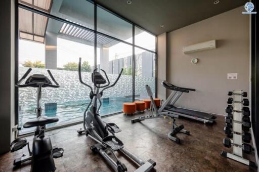 Modern home gym with exercise equipment and large windows