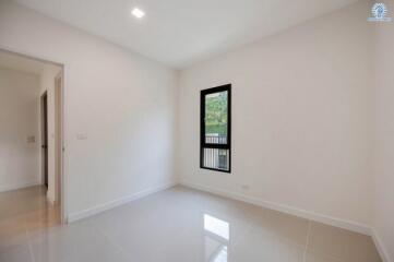 Bright empty bedroom with a large window and glossy floor