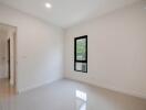 Bright empty bedroom with a large window and glossy floor