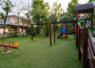 Spacious backyard with playground equipment and lush green lawn