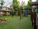 Spacious backyard with playground equipment and lush green lawn