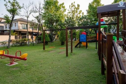Spacious backyard with playground equipment and lush green lawn