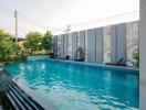 Swimming pool area with decorative wall and sun loungers