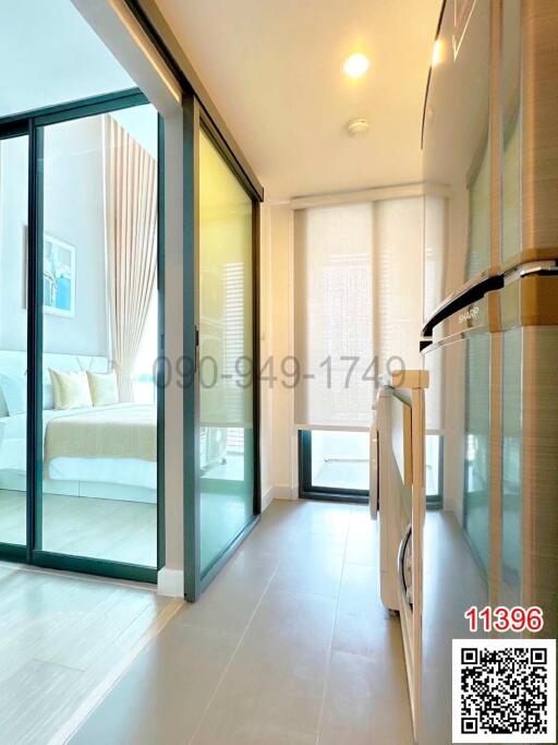 Modern building interior with a view into a bright minimalist bedroom through sliding glass doors